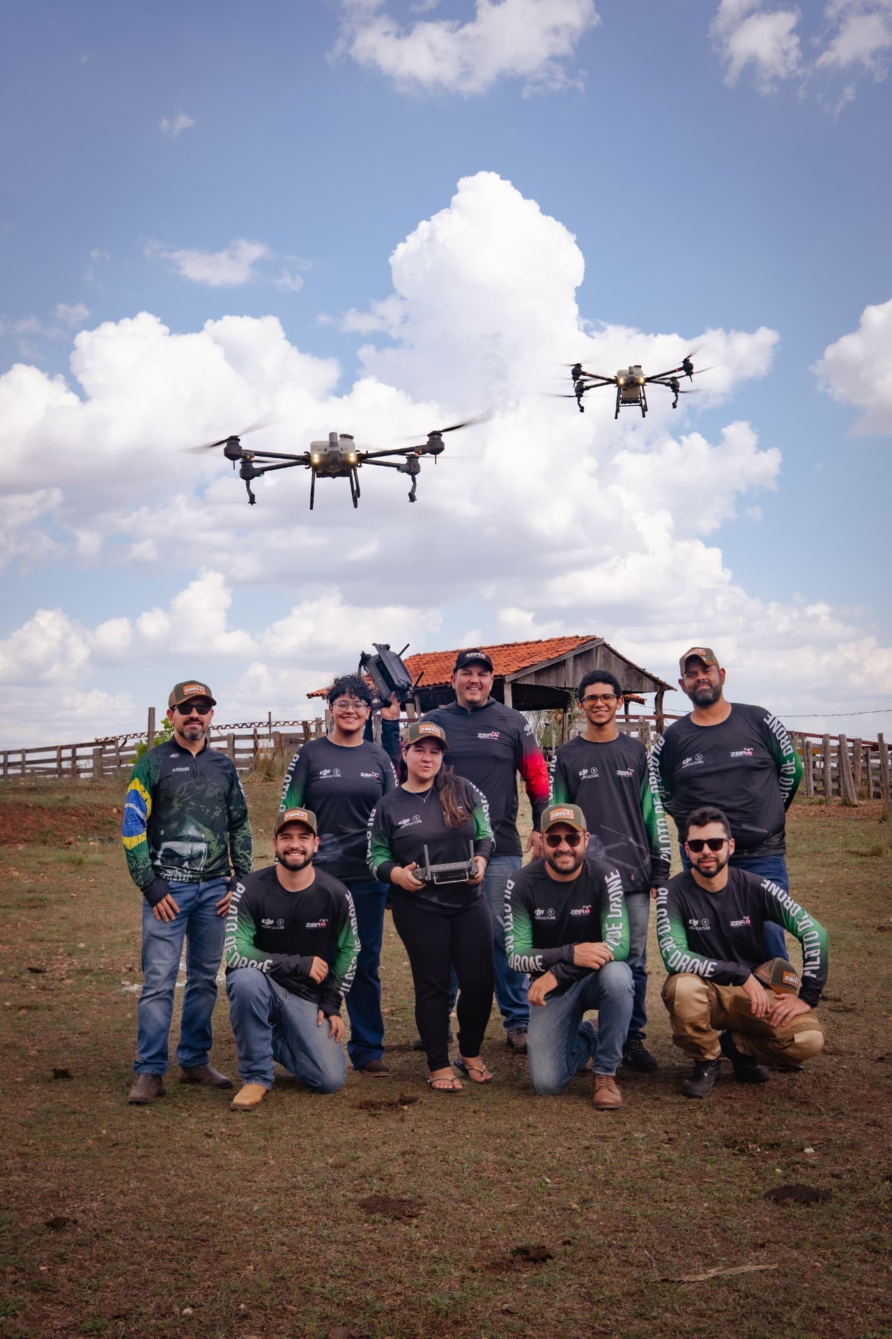 Equipe de pilotos da Zero65 Drones com dois drones agrícolas DJI Agras em voo durante operação no campo