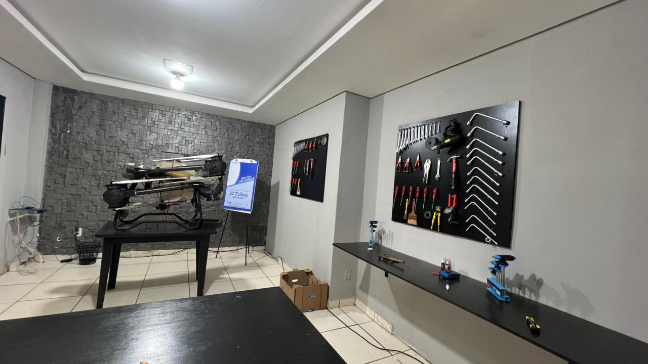 Oficina de assistência técnica da Zero65 Drones com drone em manutenção, ferramentas organizadas e bancada de reparo