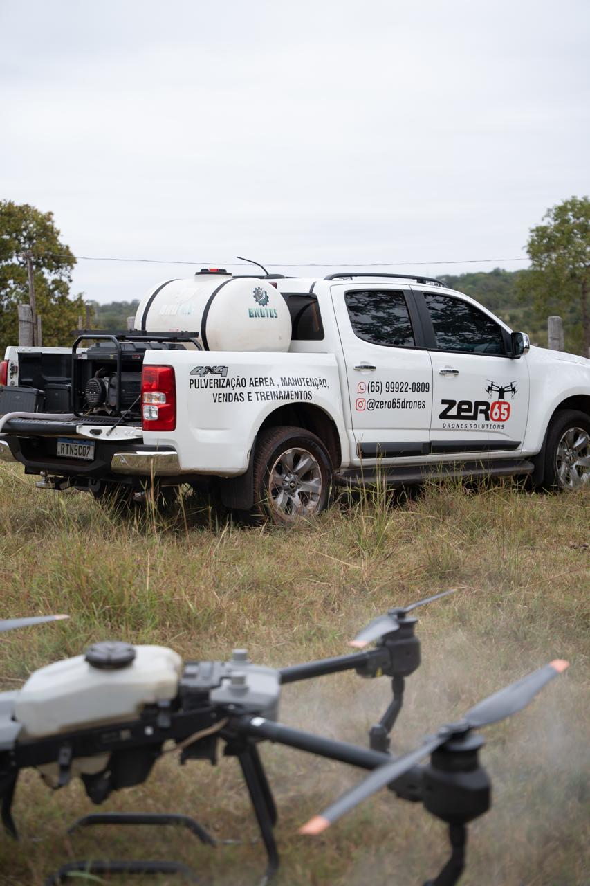 Caminhonete de apoio da Zero65 Drones com tanque de abastecimento ao lado de drone agrícola de pulverização
